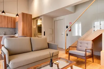 a living room with a couch and a chair at AVUS M Suites and Apartments by DA'HOME in Porto