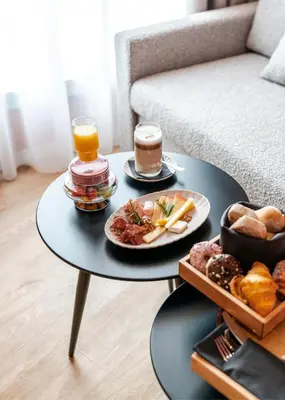 a table with two cups of coffee and a tray of food at Vincci Bonjardim in Porto