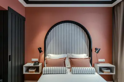 a bedroom with a large bed with orange walls at Vincci Bonjardim in Porto