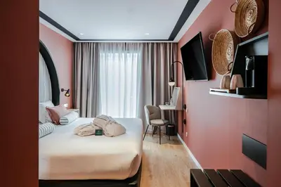 a hotel room with two beds and a desk at Vincci Bonjardim in Porto