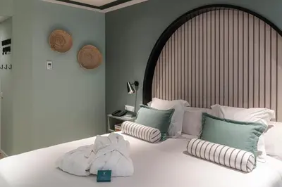 a bedroom with a large white bed with pillows at Vincci Bonjardim in Porto