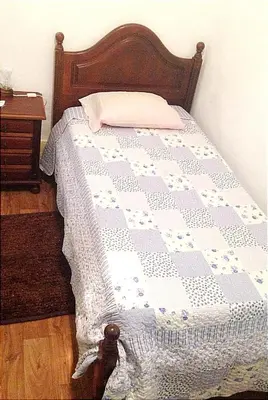 a bed with a blue and white quilt on it at Porto Chique AL 3 in Porto