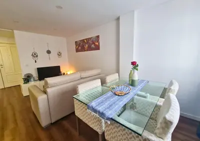 a living room with a glass table and a couch at Alegria Stay in Porto