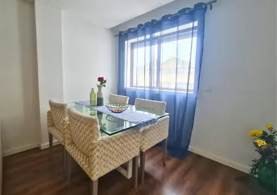 a dining room table with chairs and a window at Alegria Stay in Porto
