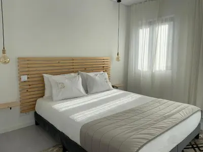 a bedroom with a large bed with a wooden headboard at Marinho's Oporto Apartments in Porto