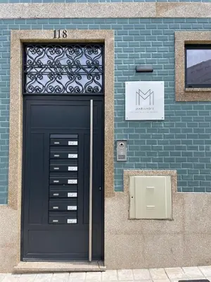 a black door on the side of a brick building at Marinho's Oporto Apartments in Porto