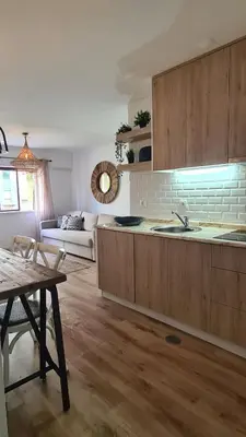a kitchen with wooden cabinets and a living room at Enjoy Porto's Vibes in Porto