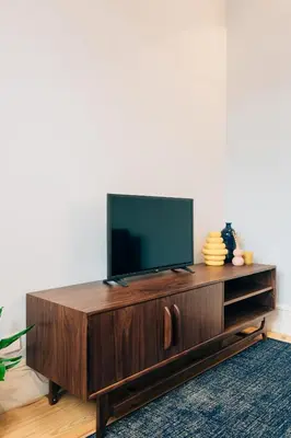 a living room with a tv on a wooden entertainment center at ORM Padrão Apartment in Porto