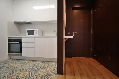 a kitchen with white cabinets and a microwave at HEART OF THE CITY 8! in Vila Nova de Gaia
