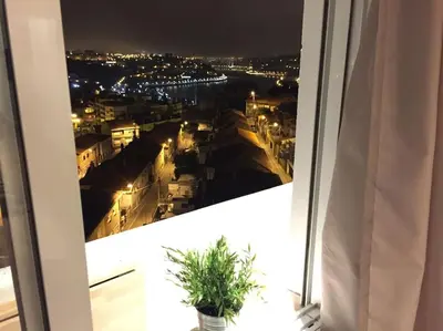 a view of a city at night from a window at HEART OF THE CITY 8! in Vila Nova de Gaia