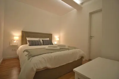 a bedroom with a large bed with two towels on it at HEART OF THE CITY 8! in Vila Nova de Gaia