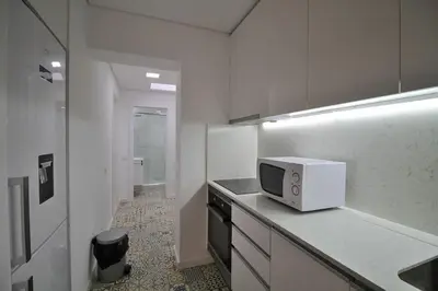 a white kitchen with a microwave on a counter at HEART OF THE CITY 8! in Vila Nova de Gaia