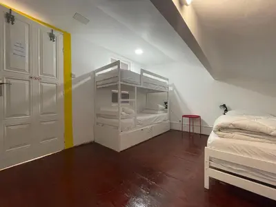 a room with two beds and a white door at Owls Hostel Ildefonso in Porto