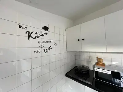 a kitchen with white tiled walls and white cabinets at Owls Hostel Ildefonso in Porto