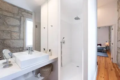 a white bathroom with a sink and a shower at VIVA Aliados Downtown in Porto