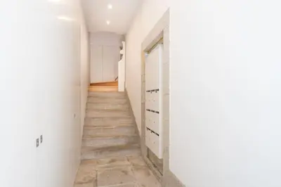 a hallway with white walls and a staircase at VIVA Aliados Downtown in Porto
