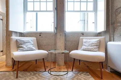 two chairs and a table in a room with windows at VIVA Aliados Downtown in Porto