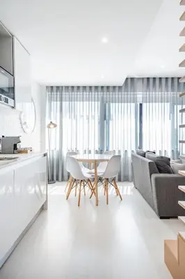 a kitchen and living room with a table and a couch at VIVA Marquês Studio in Porto