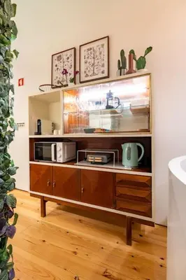 a wooden cabinet with two microwaves on top of it at VIVA Jolicoeur Porto in Porto