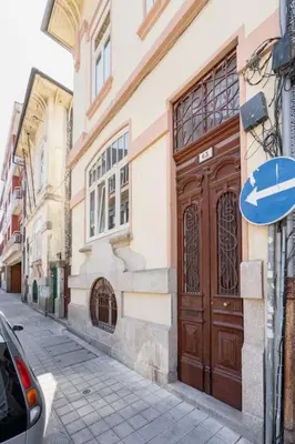 a building with a large wooden door on a street at VIVA Arts Cozy Studio in Porto