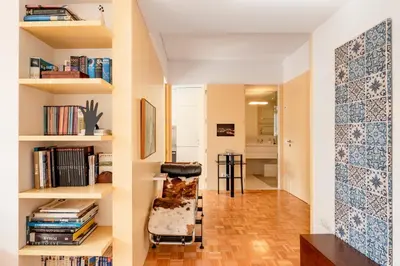 a room with a chair and bookshelves at VIVA Nanda's Place in Porto