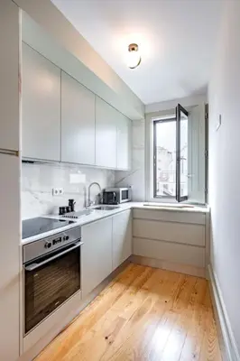a kitchen with white cabinets and a sink and a window at VIVA Formosa Flat in Porto