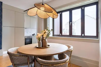 a dining room table with chairs and a vase of flowers at VIVA Formosa Flat in Porto