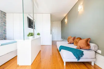 a bedroom with a white couch with pillows on it at VIVA Mosaics Studio in Porto