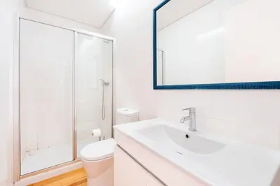 a bathroom with a sink and a toilet and a mirror at VIVA Mosaics Studio in Porto