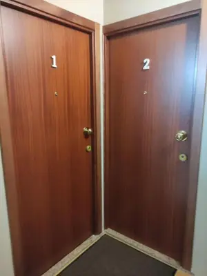 two wooden doors in a room with at Leote House - Studio 2 in Porto