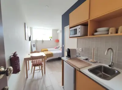 a kitchen with a sink and a room with a bed at Leote House - Studio 2 in Porto