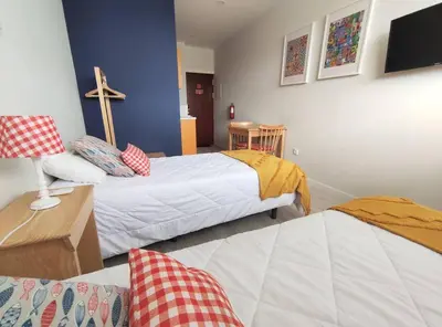 a room with two beds and a cross on the wall at Leote House - Studio 2 in Porto