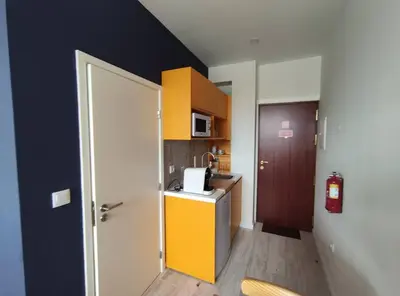 a small kitchen with a yellow counter and a door at Leote House - Studio 2 in Porto