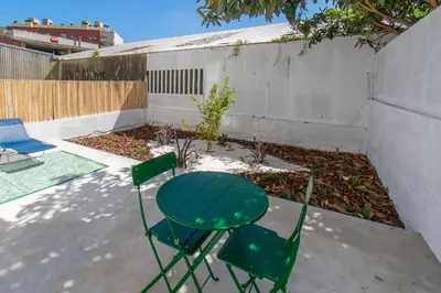 a green table and two chairs in a backyard at Leote House - Studio 4 in Porto