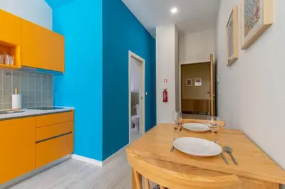 a kitchen with a wooden table and a blue wall at Leote House - Studio 4 in Porto