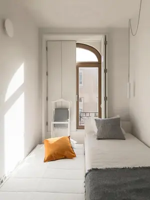 a bedroom with a bed with an orange pillow on it at Boavista 2-Bedroom Apartment in Porto