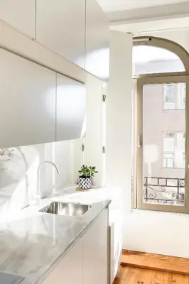 a white kitchen with a sink and a window at Boavista 2-Bedroom Apartment in Porto