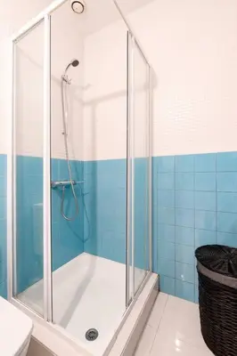 a shower in a bathroom with blue tiles at VIVA Old Franciscan Studio in Porto