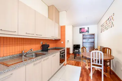 a kitchen with a sink and a table in a room at VIVA Old Franciscan Studio in Porto