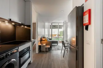 a kitchen with a washer and dryer and a living room at Patio in Central Porto in Porto