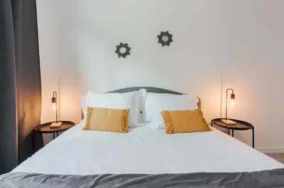 a bedroom with a white bed with two lamps at Great Location very Central Boavista in Porto