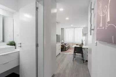 a white kitchen with a table and a chair at Great Location very Central Boavista in Porto