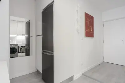 a black refrigerator in a white room with a kitchen at Great Location very Central Boavista in Porto