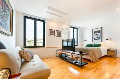 a living room with a couch and a tv at Fontainhas Royal in Porto