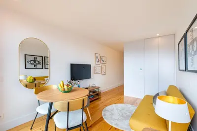 a living room with a table and chairs and a tv at Fontainhas Royal in Porto