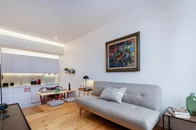 a living room with a couch and a kitchen at Fontainhas Royal in Porto