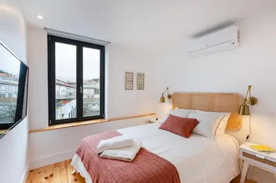 a bedroom with a large bed and a window at Fontainhas Royal in Porto