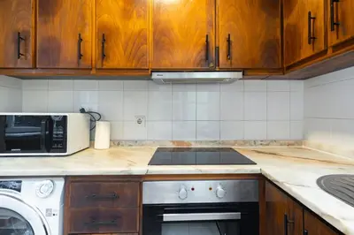 a kitchen with wooden cabinets and a stove and a microwave at GuestReady - Miragaia Blue in Porto