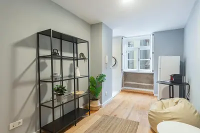 a living room with a black book shelf at GuestReady - Miragaia Blue in Porto