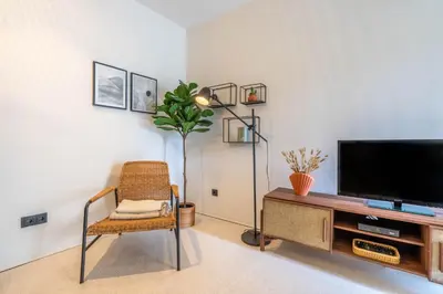 a living room with a chair and a flat screen tv at The Priest's Home by LovelyStay in Porto